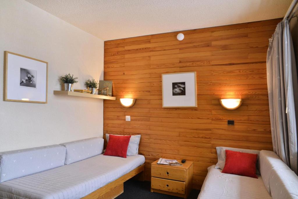 - un salon avec un canapé et un mur en bois dans l'établissement Residence 3000 - Studio pour 4 Personnes 98, à Mâcot La Plagne