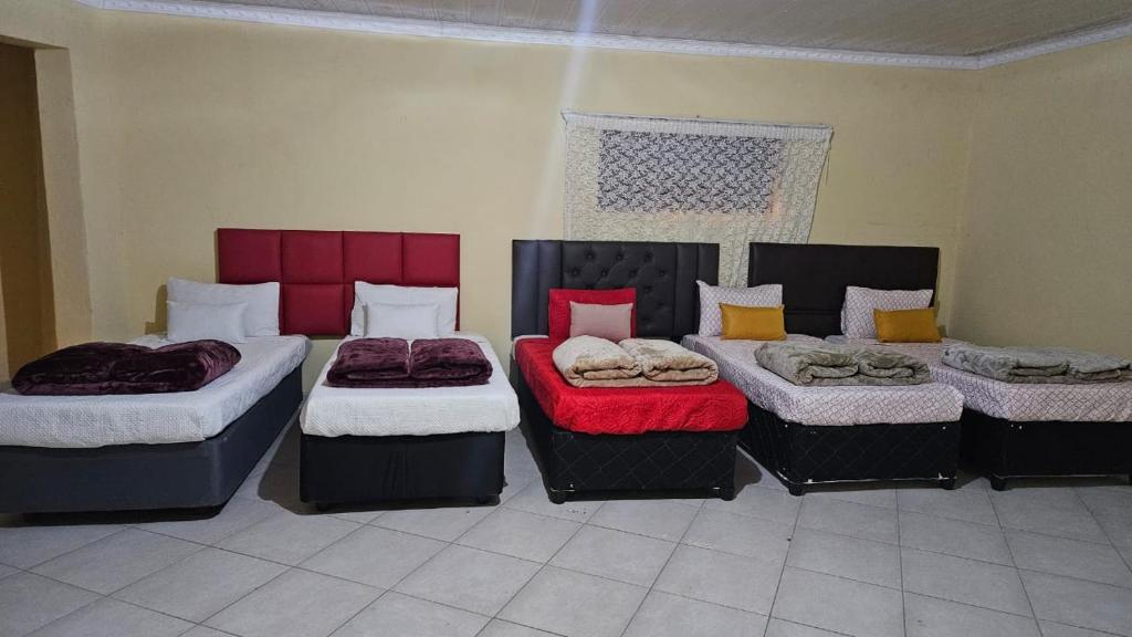 a room with four beds in a room at Goodlife guest house in klerksdorp in Klerksdorp