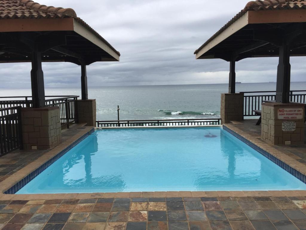 a swimming pool with the ocean in the background at 601 Bali Hai in Westbrook