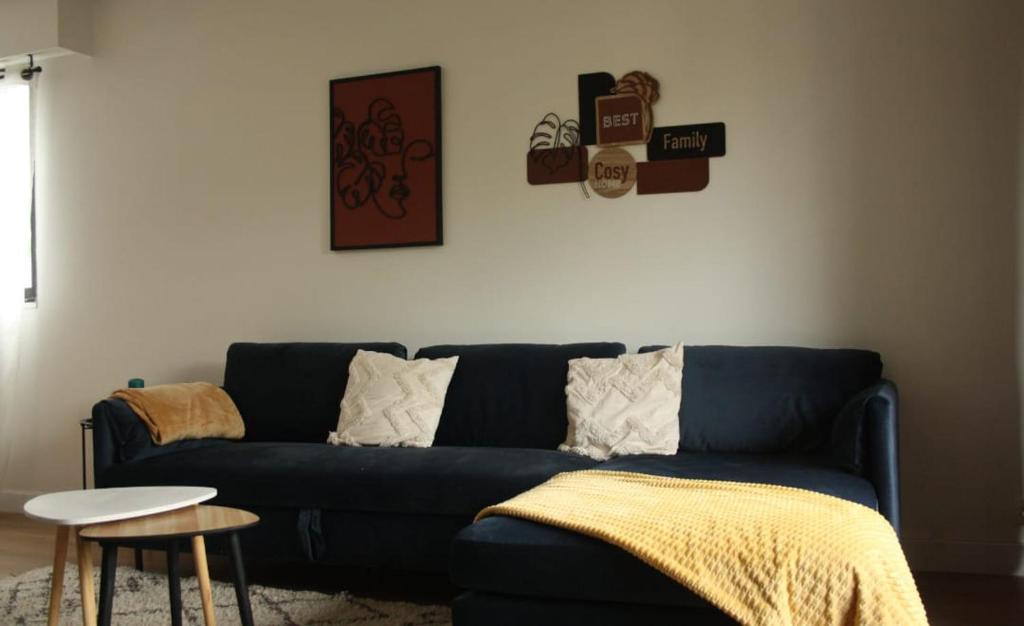 un salon avec un canapé bleu et une table dans l'établissement Appartement moderne 3 ch-5pers- 15min de Paris, à Enghien-les-Bains