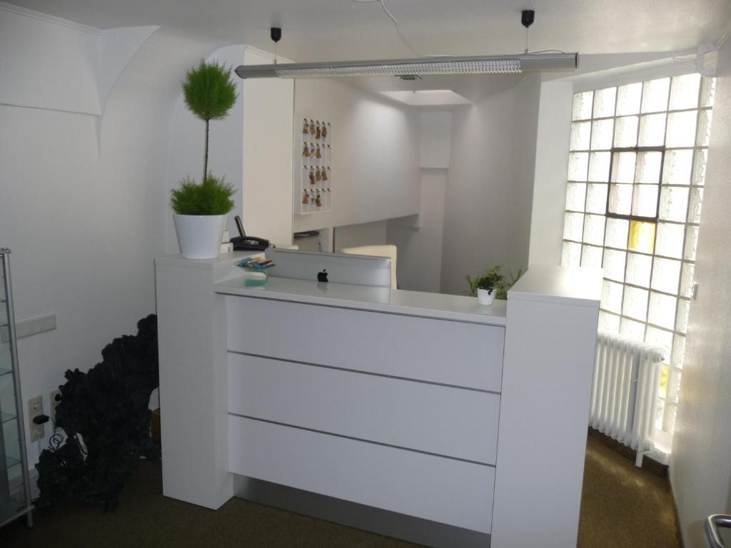 a white counter in a room with two windows at Hotel Sechzehn in Leverkusen