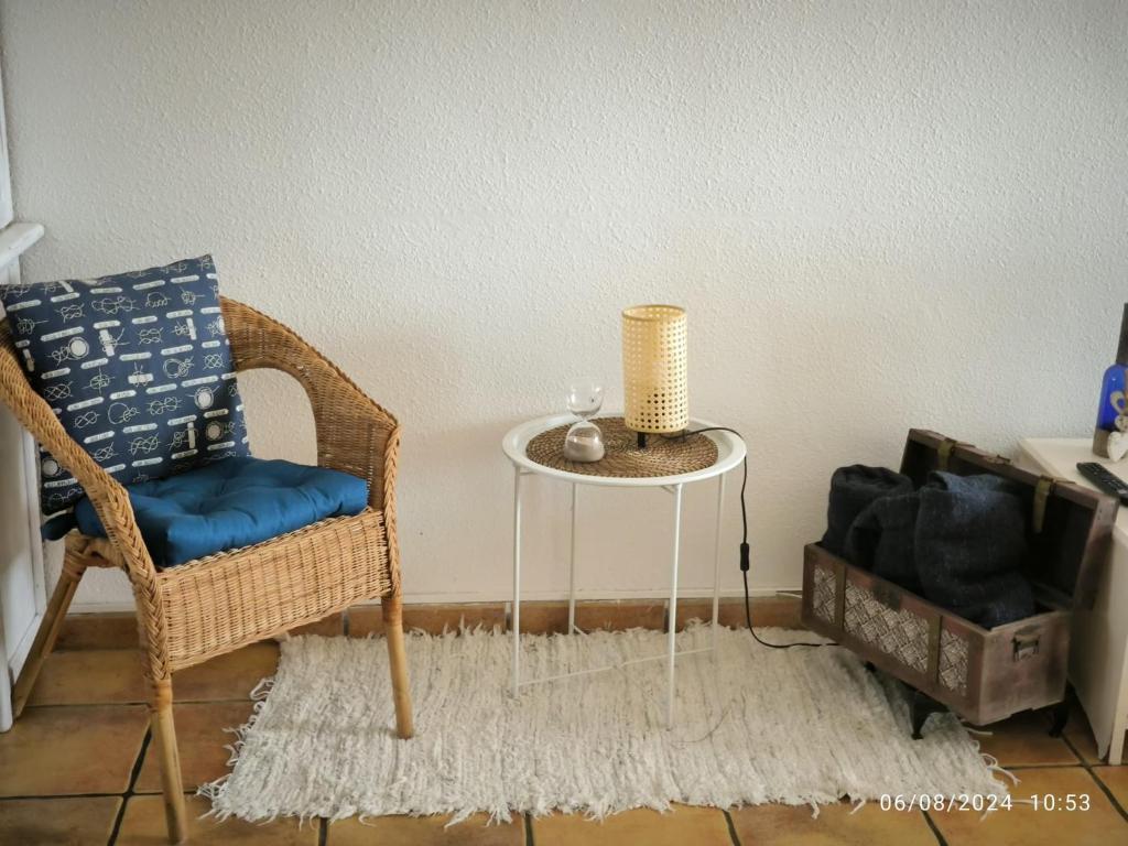 a wicker chair and a table in a room at Casa Frasca in Teguise