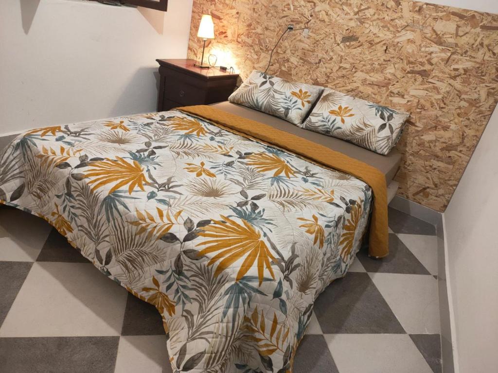 a bedroom with a bed with a floral comforter at Dar lmedina in Essaouira