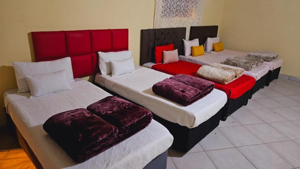 a group of four beds in a room at Goodlife guest house in klerksdorp in Klerksdorp