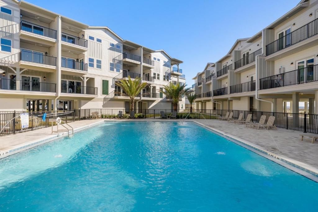 a swimming pool in front of apartment buildings at Sharkey's by Pristine Properties Vacation Rentals in Cape San Blas