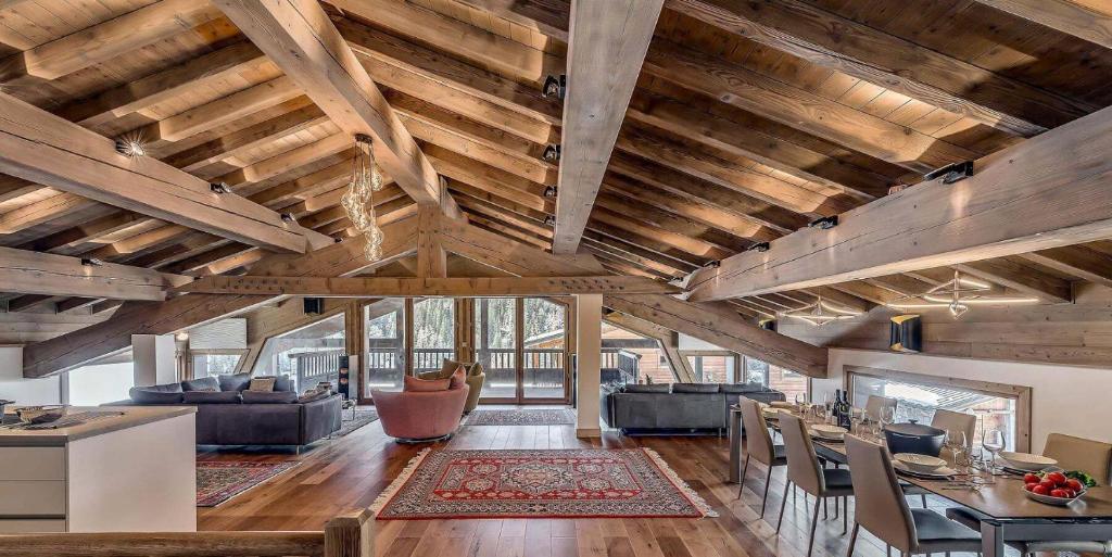 - un salon avec des plafonds en bois, une table et des chaises dans l'établissement Résidence Casa Alba - Casa Alba 5 - duplex rénové 250m2 - Jacuzzi, sauna MAE-1494, à Tignes