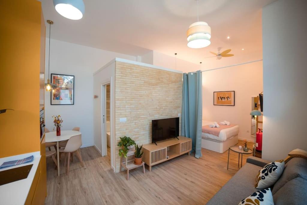 a living room with a couch and a television in a room at Lofts Orense E Moderno y cercano a la playa in Valencia