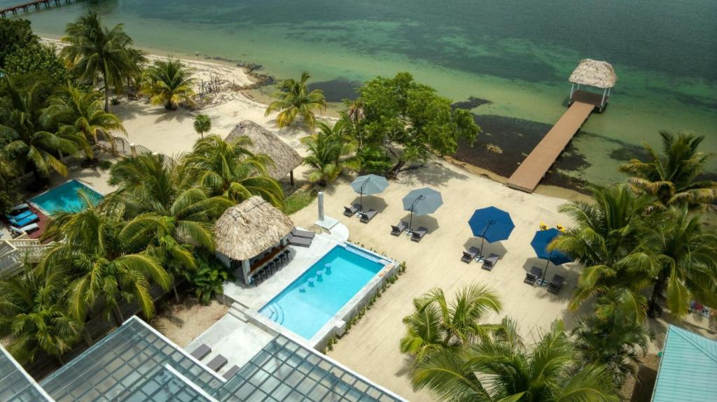 an aerial view of a resort with a swimming pool and a beach at Conmigo Villas - 6 Bedroom Beachfront w Pool in Maya Beach