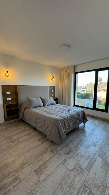 a bedroom with a large bed and a large window at Rockaway Apart in Miramar