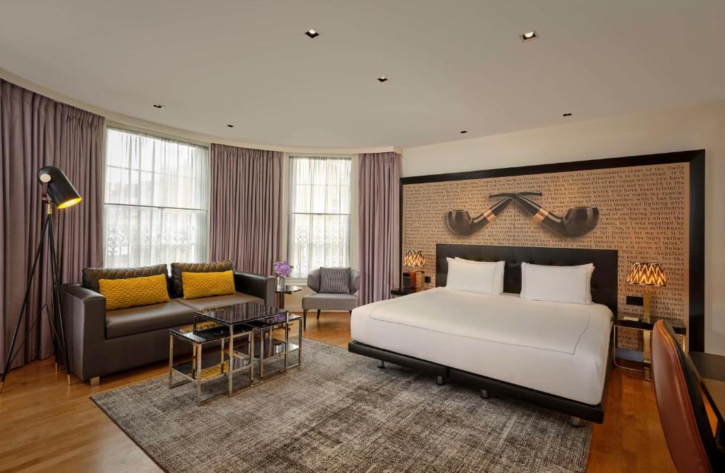 a bedroom with a large white bed and a couch at Holmes Hotel London in London