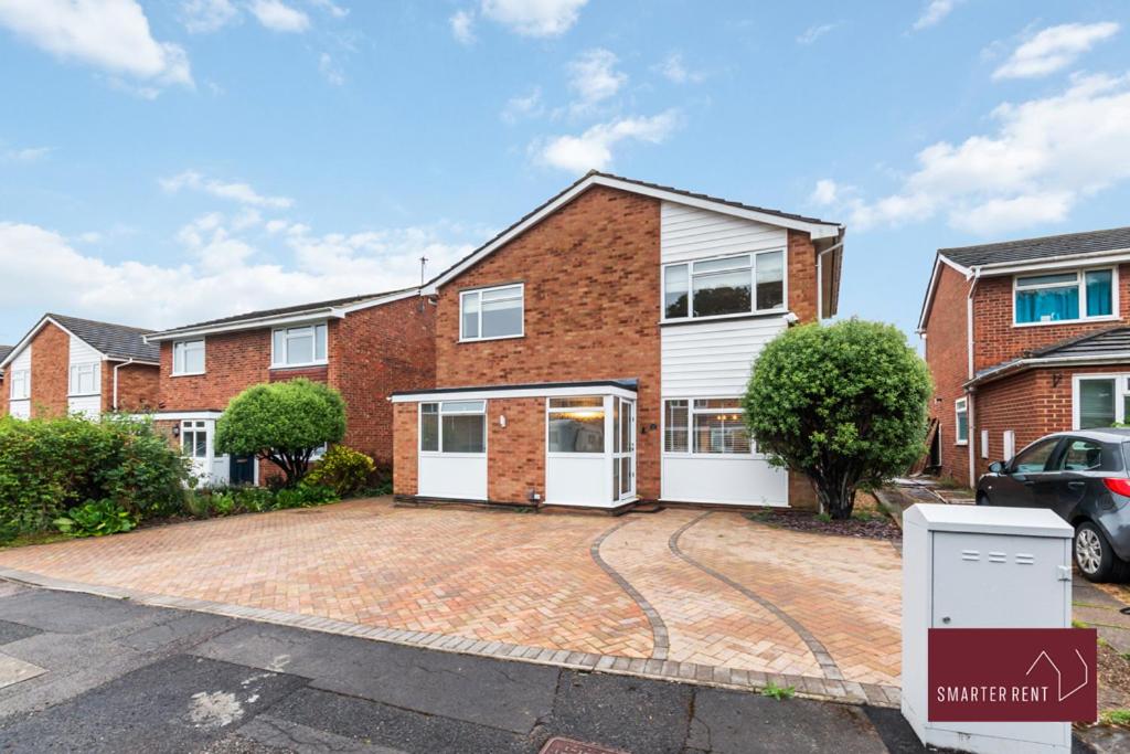 a brick house with white doors and a driveway at Guildford - 4 Bedroom House - Private Parking in Guildford