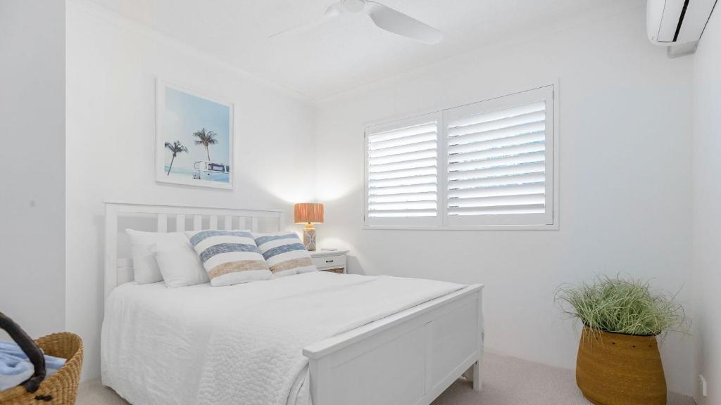 a white bedroom with a white bed and a window at Unit 3 21 Park Generous and Comfortable Beachside Abode in Sunshine Beach