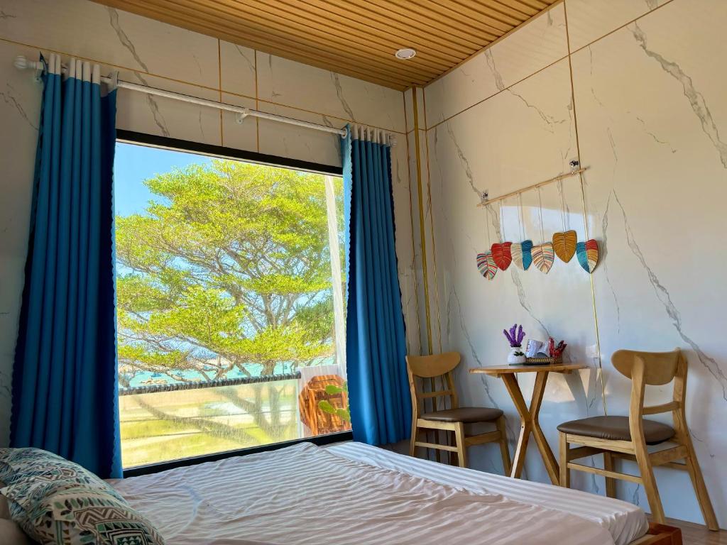 a bedroom with a bed and a large window at Homestay Vitamin SEA - View Biển Phú Quý in Cu Lao Thu