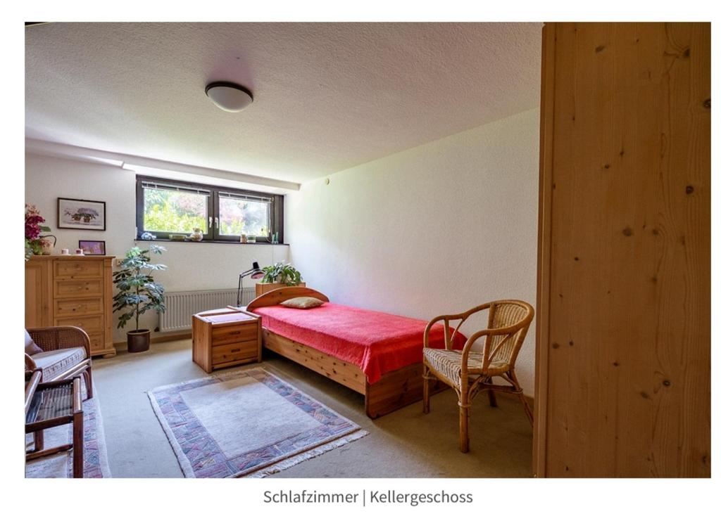 Un dormitorio con una cama y una mesa y sillas. en Cozy basement guest room in quietness, en Hannover