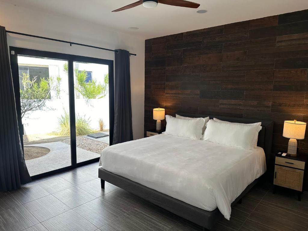 a bedroom with a large bed and a large window at Casa Santos Pedregal in Cabo San Lucas