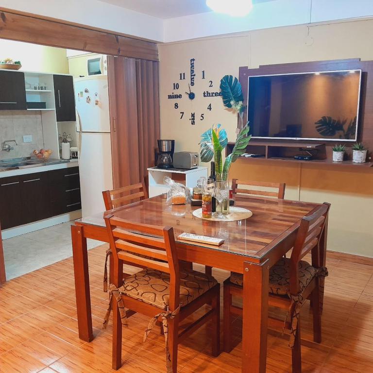 a wooden dining room table with chairs and a television at Villa Lainez in Villa Mercedes