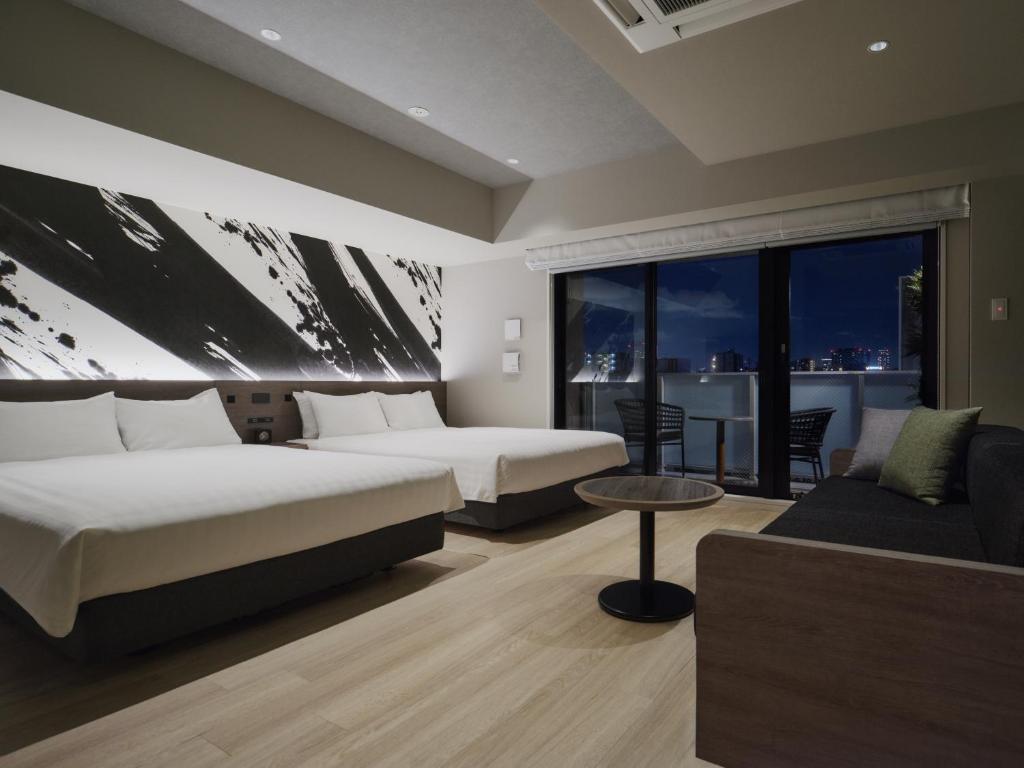 a hotel room with two beds and a couch at MONday Apart Premium Asakusa in Tokyo