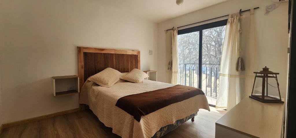una camera da letto con un letto e una grande finestra di SJ Departamentos, Salta a Salta