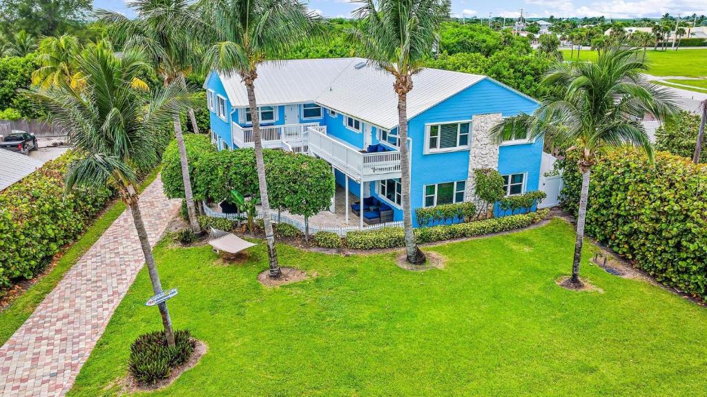 an aerial view of a blue house with palm trees at Ultimate Group Escape - 8BD Oceanfront Beach House in Fort Pierce
