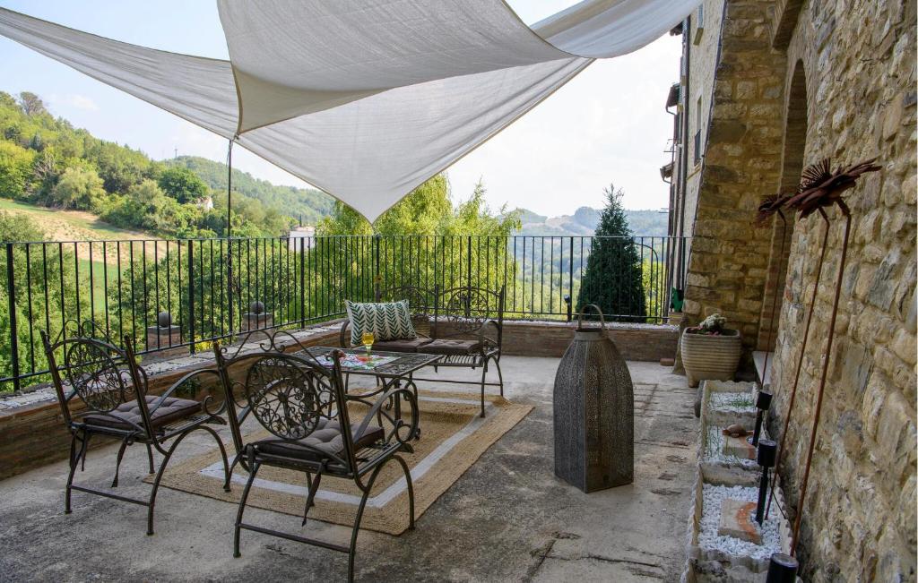 a patio with a table and chairs on a balcony at Stunning Home In Macerata Feltria in Macerata Feltria