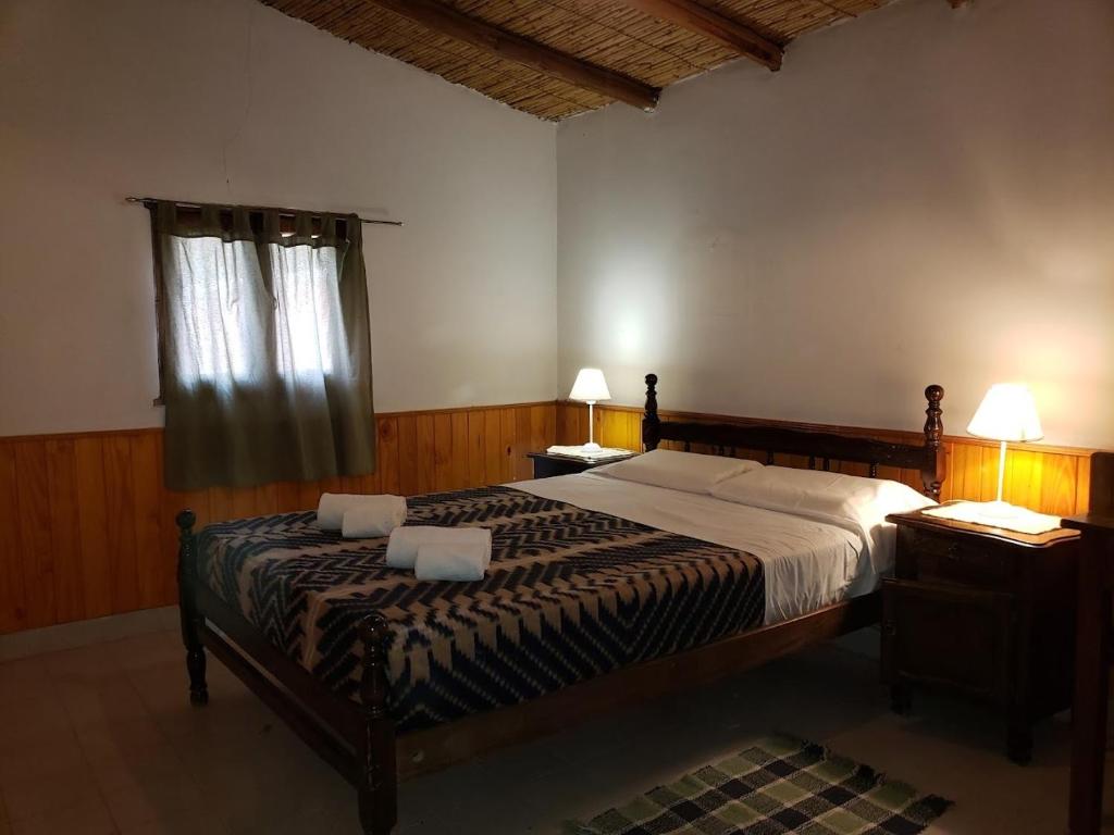 a bedroom with a bed with two night stands and two lamps at Cabañas El Molino in Senador Pérez