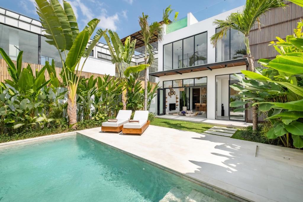 Una vista exterior de una casa con piscina. en Aquamarine Tanah Barak, en Canggu