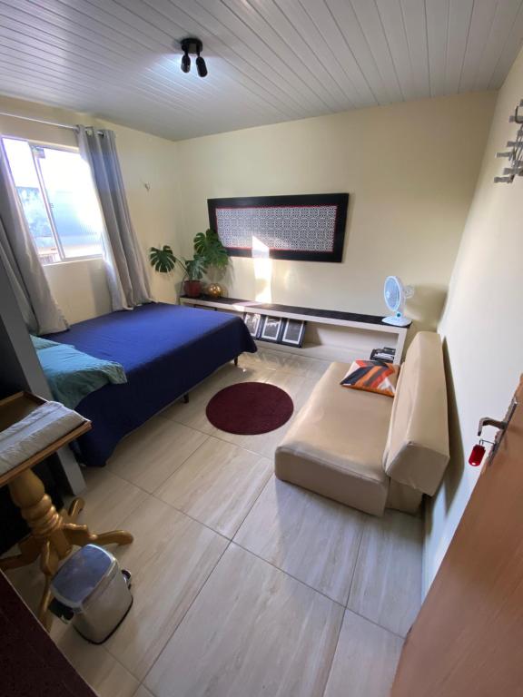 a bedroom with a bed and a couch and a table at Quarto - Nosso lar em Natal in Natal