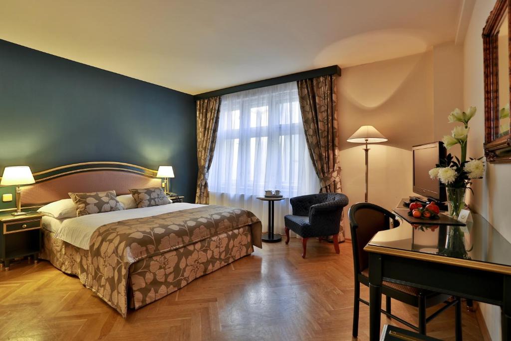 Habitación de hotel con cama y escritorio en Elysee Hotel, en Praga