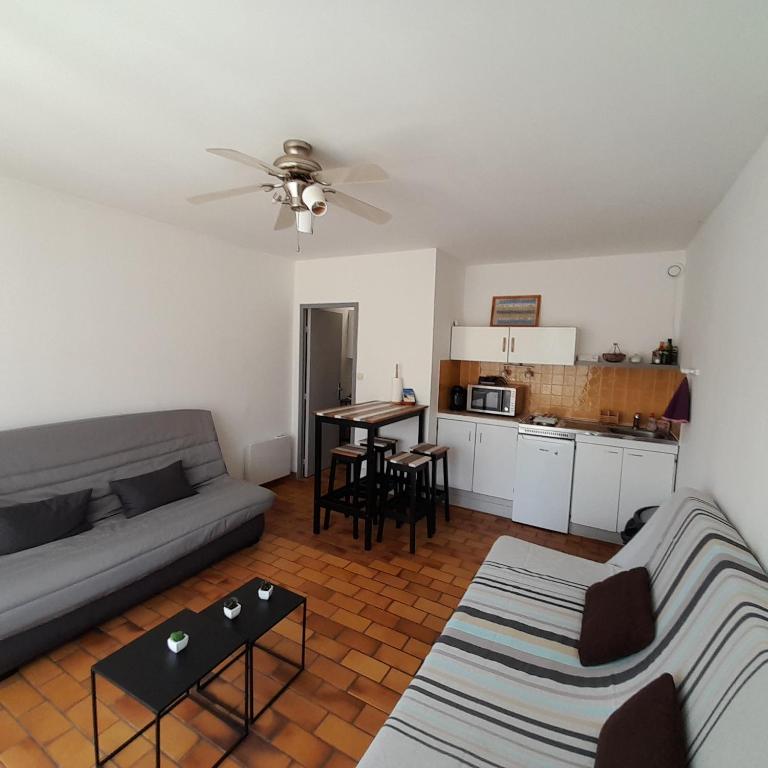 a living room with a couch and a table at Au calme à 2min mer Parking Balcon Wifi Clim! in Six-Fours-les-Plages