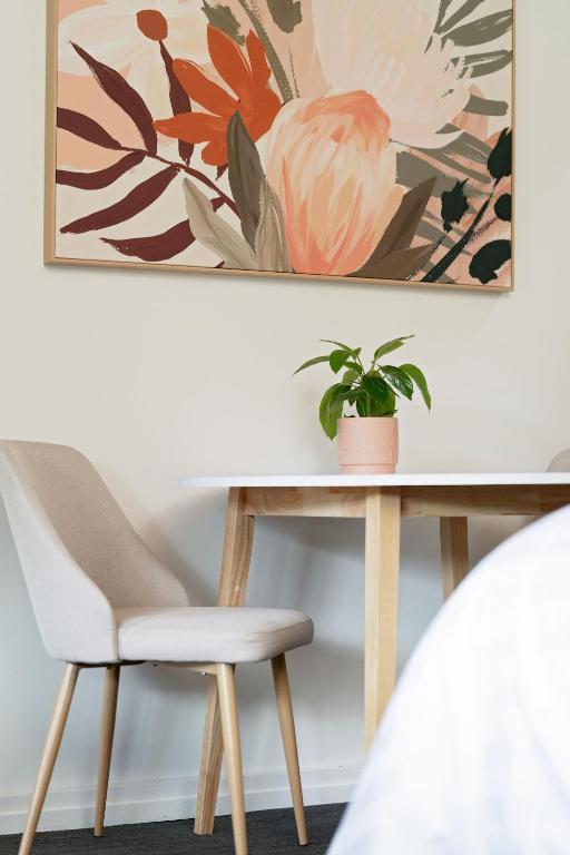 a white table with a chair and a plant at Mount Lofty Golf Course in Bridgewater