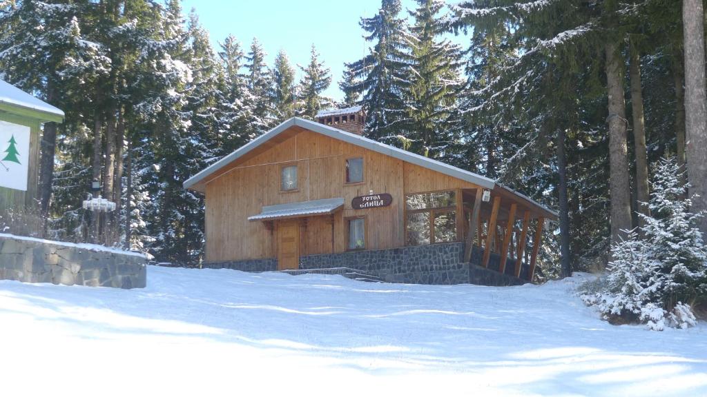 eine große Holzhütte im Wald im Schnee in der Unterkunft Elitza Villa in Pamporowo