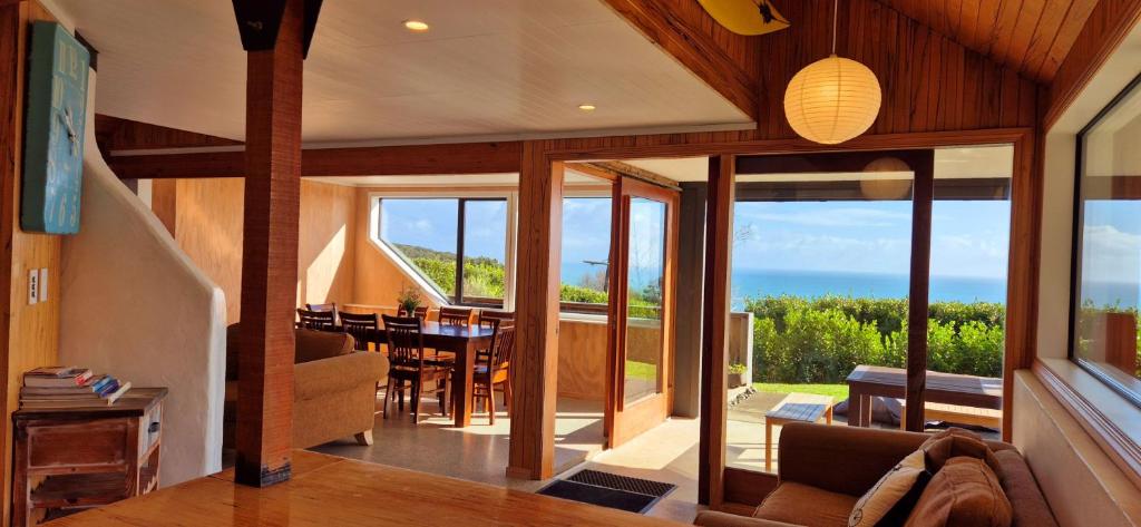 a living room with a view of the ocean at Tawa Whare holiday accommodation in Raglan