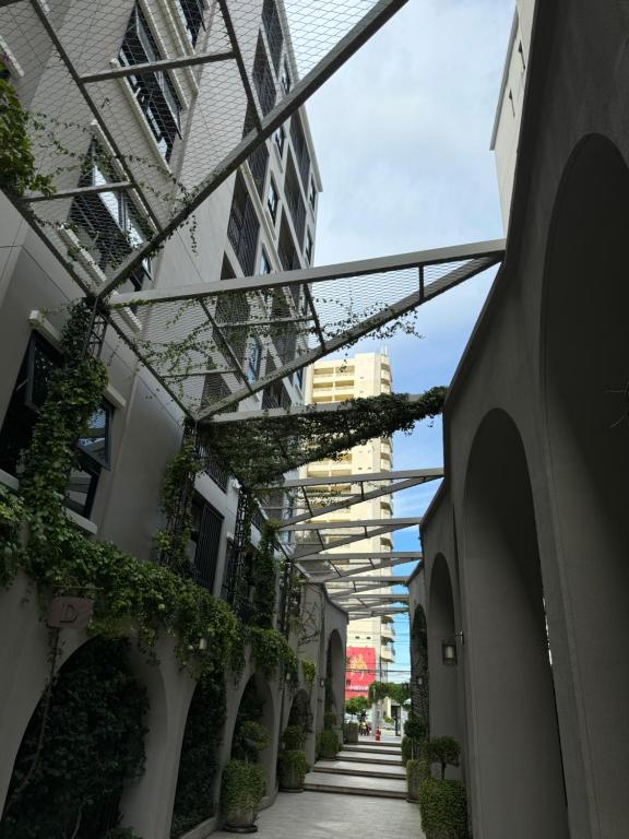 una pasarela con plantas al lado de un edificio en Студия, en Hua Hin
