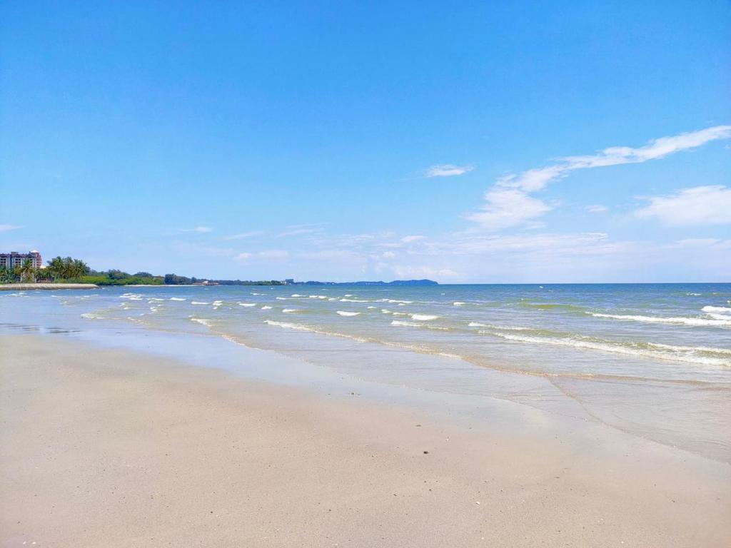 a beach with the ocean and some birds in the water at Sunshine Bay Resort by NG in Port Dickson