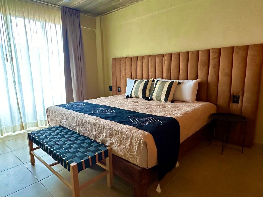 a bedroom with a large bed with a wooden headboard at Lolitas Suites 303 in Zihuatanejo