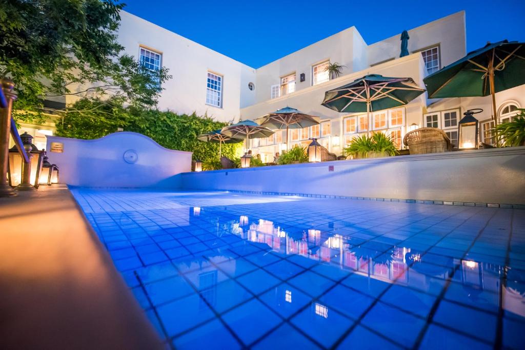 una piscina frente a un hotel por la noche en Hout Bay Manor en Hout Bay