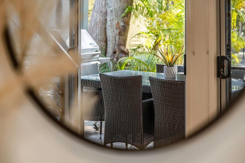 a reflection of a table and chairs in a mirror at Mobys 29 in Boomerang Beach