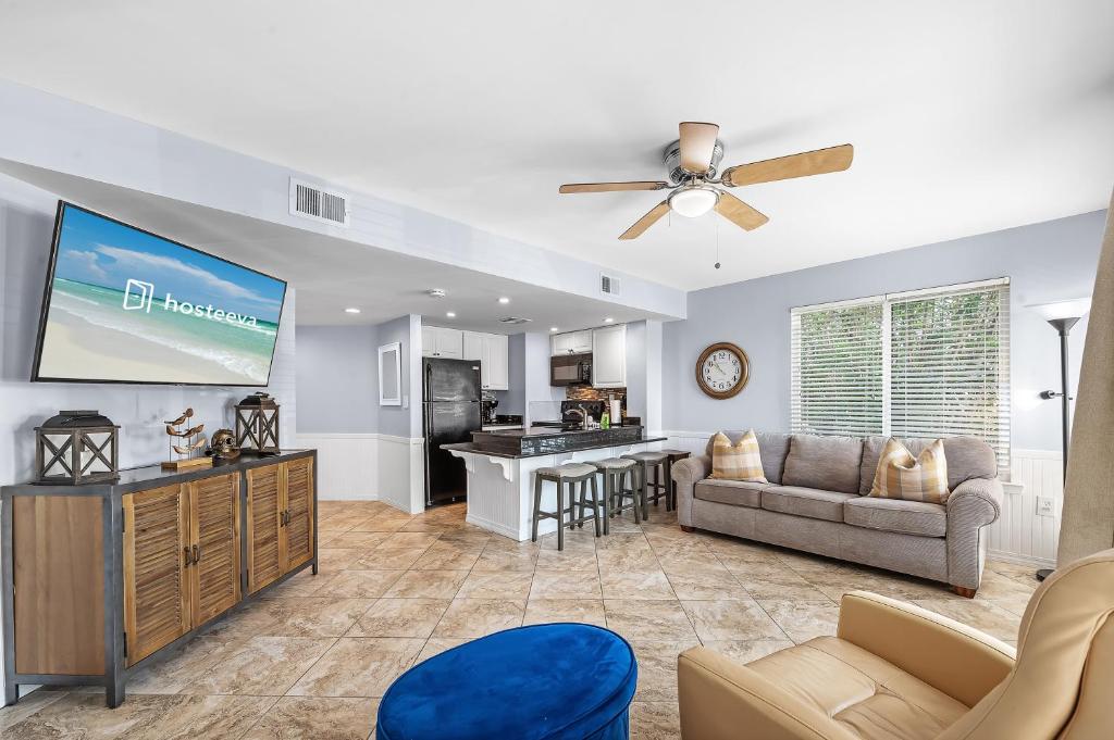 a living room with a couch and a tv at Plantation West Condos in Gulf Highlands