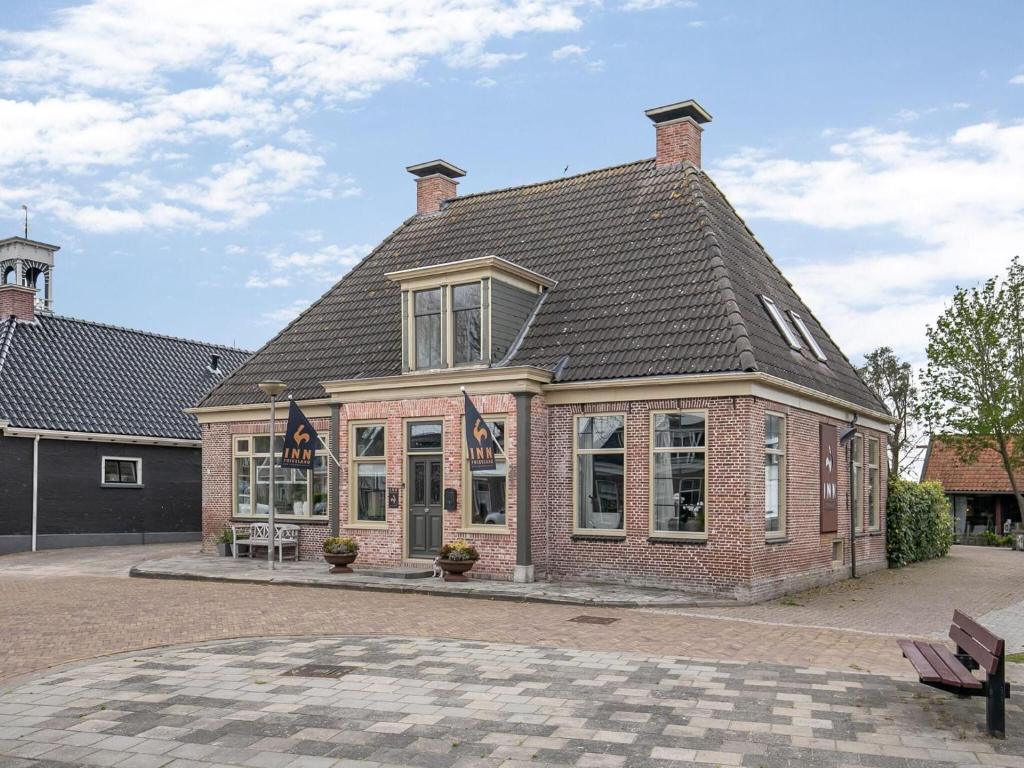 a large brick building with a roof at Guesthouse Friesland Ternaard near Heritage in Ternaard