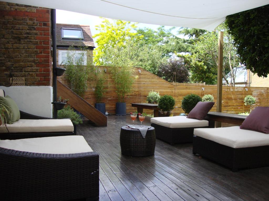 un patio con 2 sofás y una mesa en LondonHomeGardens, en Londres