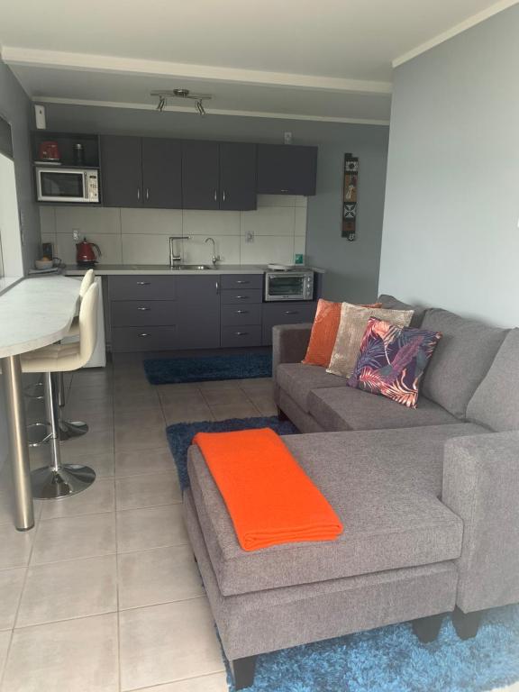 a living room with a couch and a kitchen at Mason lane Apartment in Whangarei