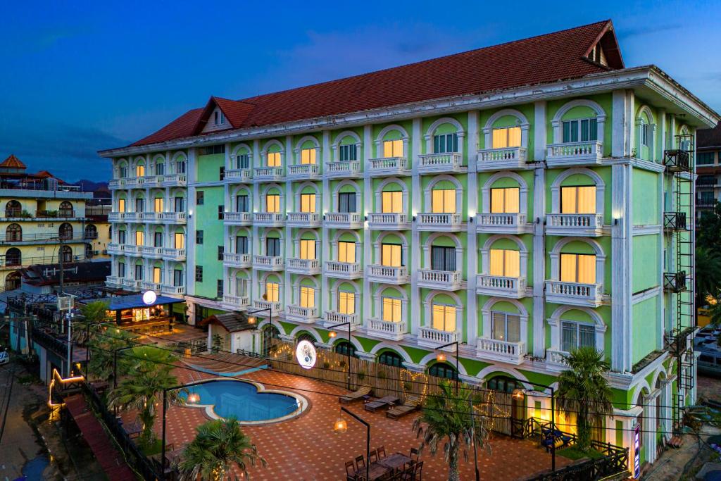 a large building with a pool in front of it at Lisha Roungnakhone Hotel in Vang Vieng