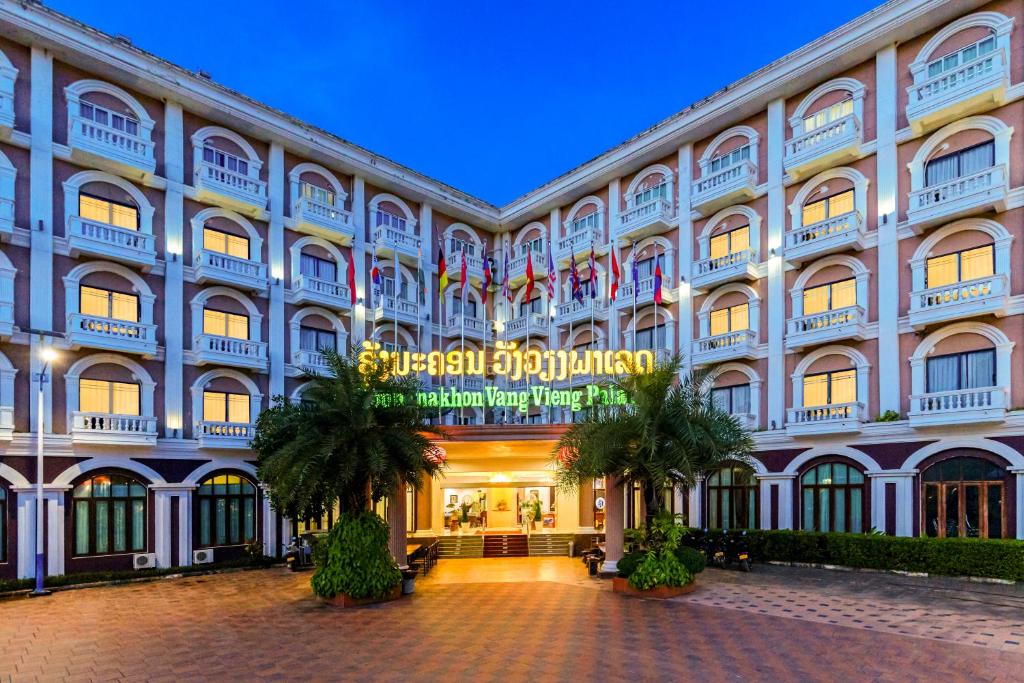 a large building with a sign in front of it at Lisha Roungnakhone Hotel in Vang Vieng