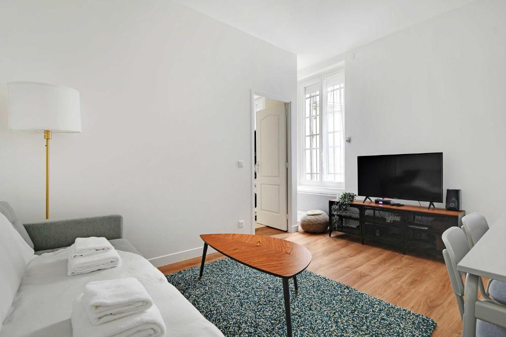 un salon avec un canapé et une table dans l'établissement Comfortable apt - 1BD - 4P - Montmartre, à Paris