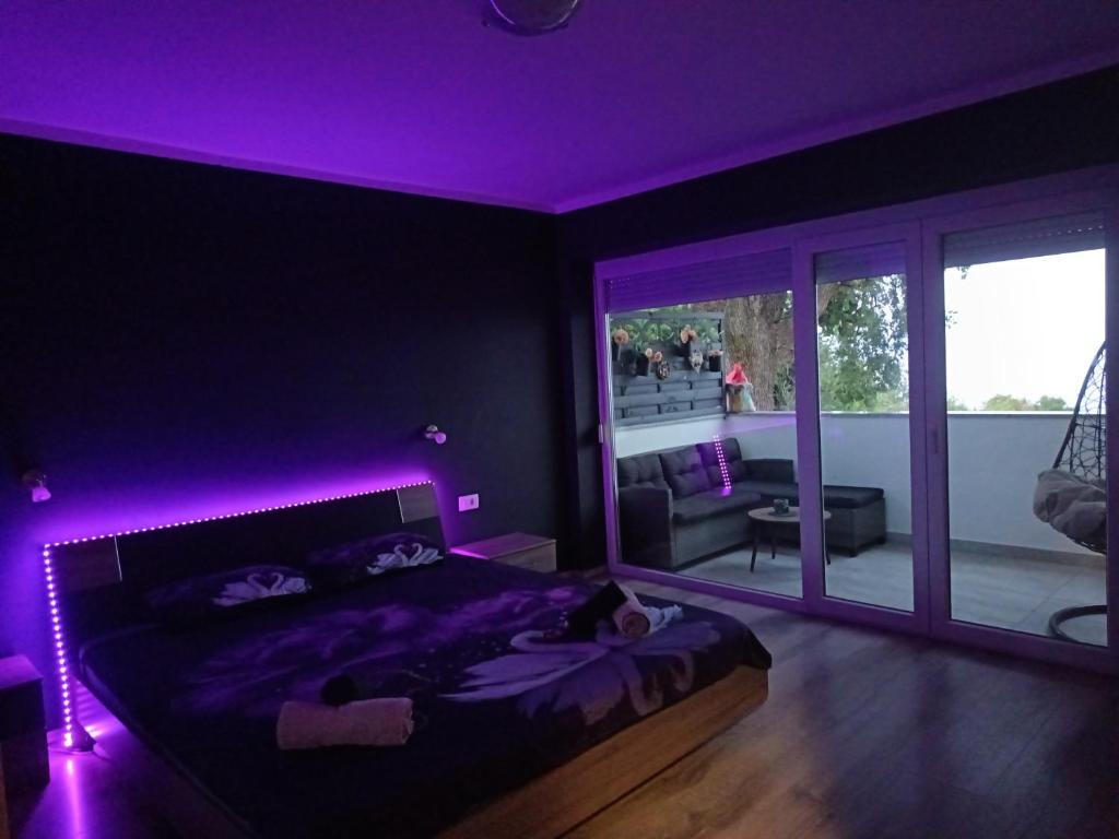 a bedroom with a bed with a purple lighting at Apartment D&J 2 in Mošćenička Draga