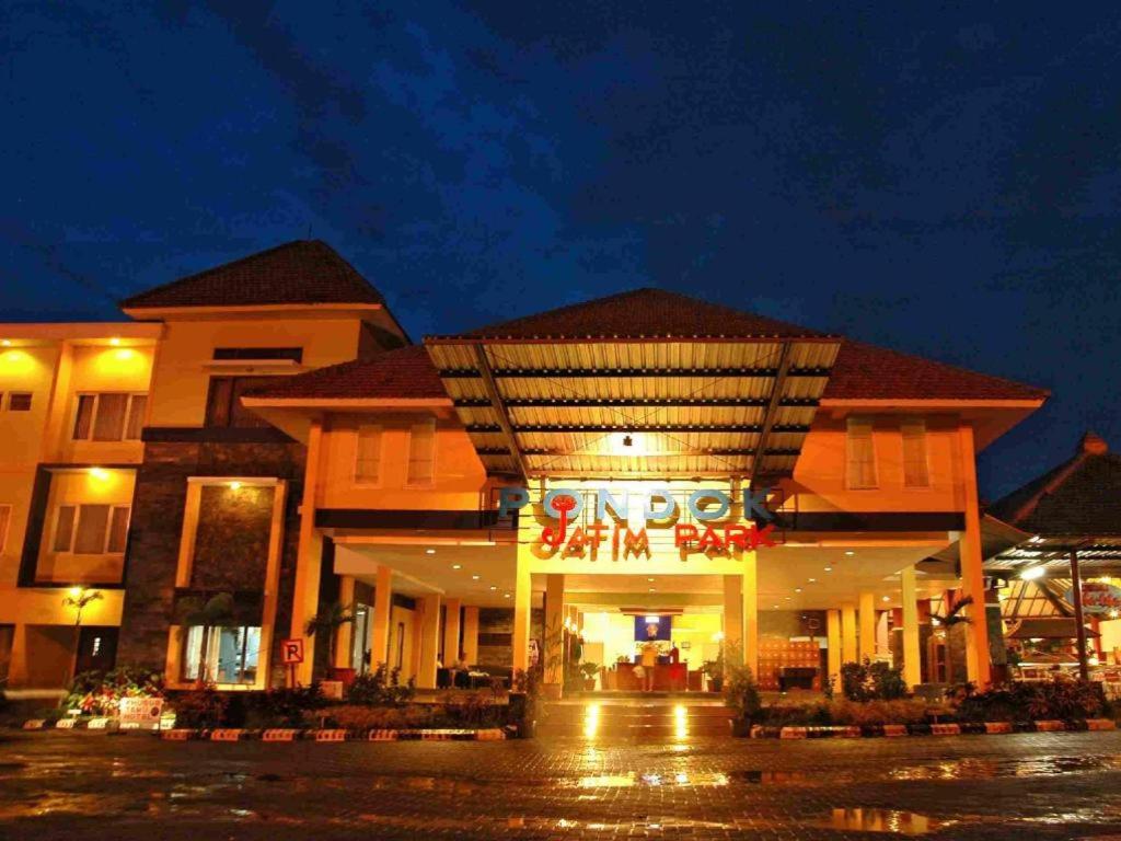 a building with a sign in front of it at night at Pondok Jatim Park Hotel & Cafe in Batu