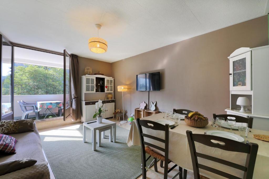 un salon avec une table et une salle à manger dans l'établissement Le Carbet des Oursons - Appt à Bresse vue montagne, à La Bresse
