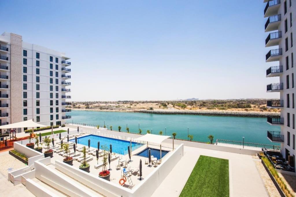 eine Luftansicht eines Gebäudes und eines Wasserkörpers in der Unterkunft Lovely Waterfront Private 2BR Apartment Yas Island in Abu Dhabi
