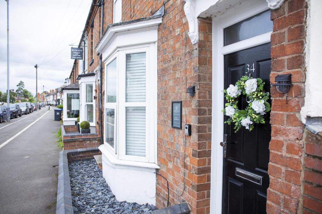 a building with a door with a flower arrangement on it at 34 Evesham Road - Studio Apartment in Shottery