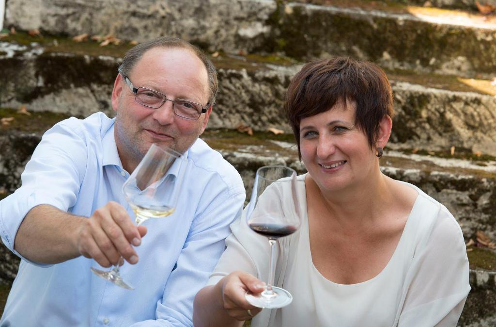 a man and a woman holding glasses of wine at Remushof Jagschitz in Oslip